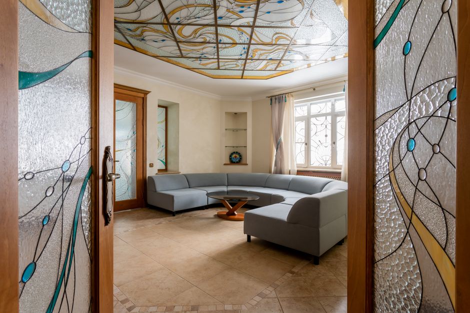 Helles Wohnzimmer mit sichtbarem Wasserfleck an einer weißen Decke nahe der Deckenleuchte
