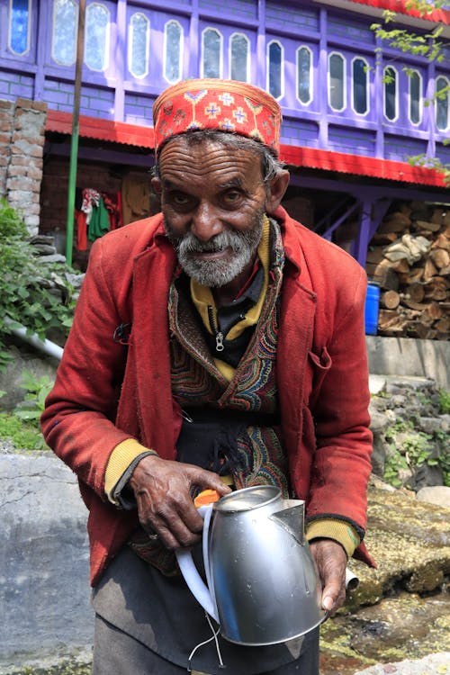 Elderly Man in Jacket Standing with Kettle