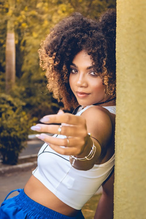 A woman with curly hair pointing at something