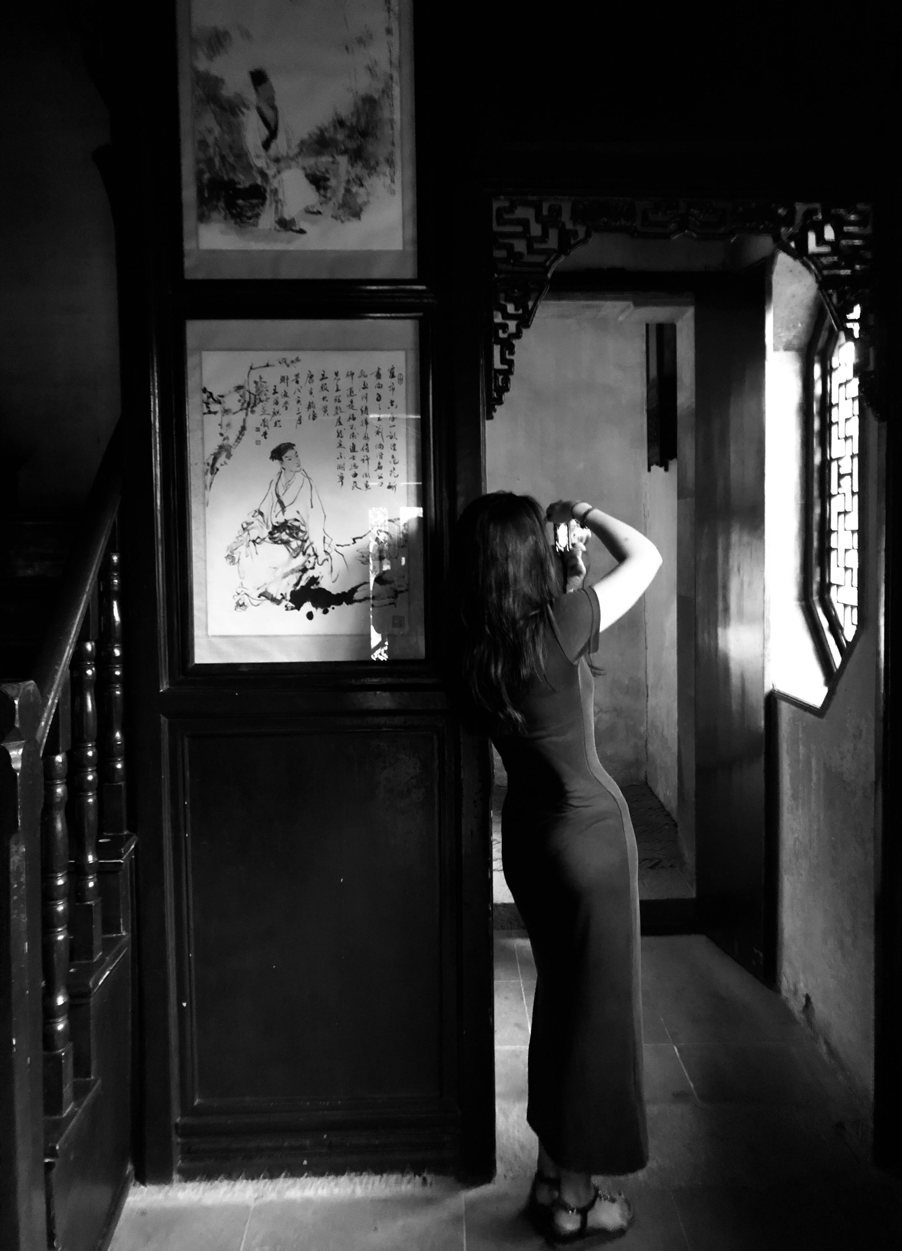 woman leaning on wooden wall near stairs