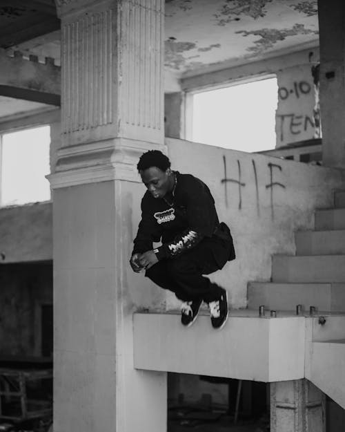 A man is sitting on some stairs with a skateboard