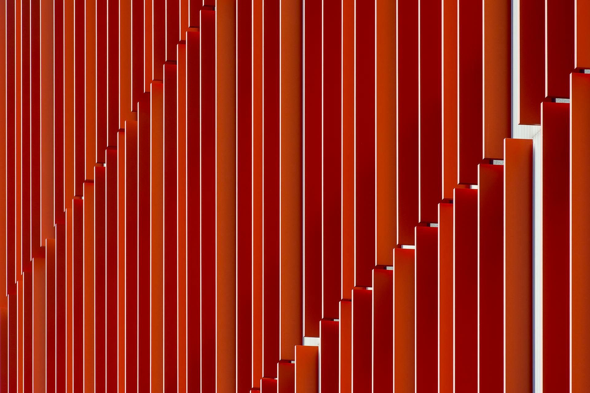 Abstract image of a red facade in Rotterdam exhibiting modern architectural patterns and repetition.
