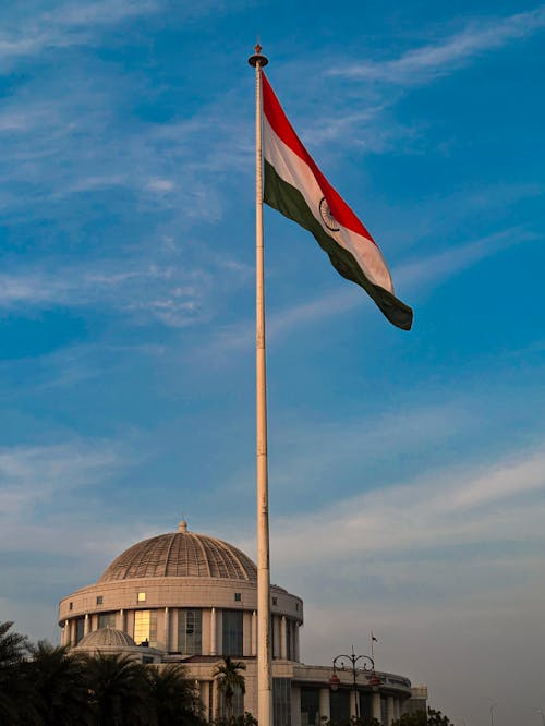 The indian flag is flying in front of a building