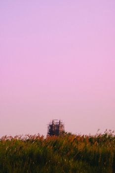 Sunset view of a construction site amidst rural fields in Cao Lãnh, Vietnam.