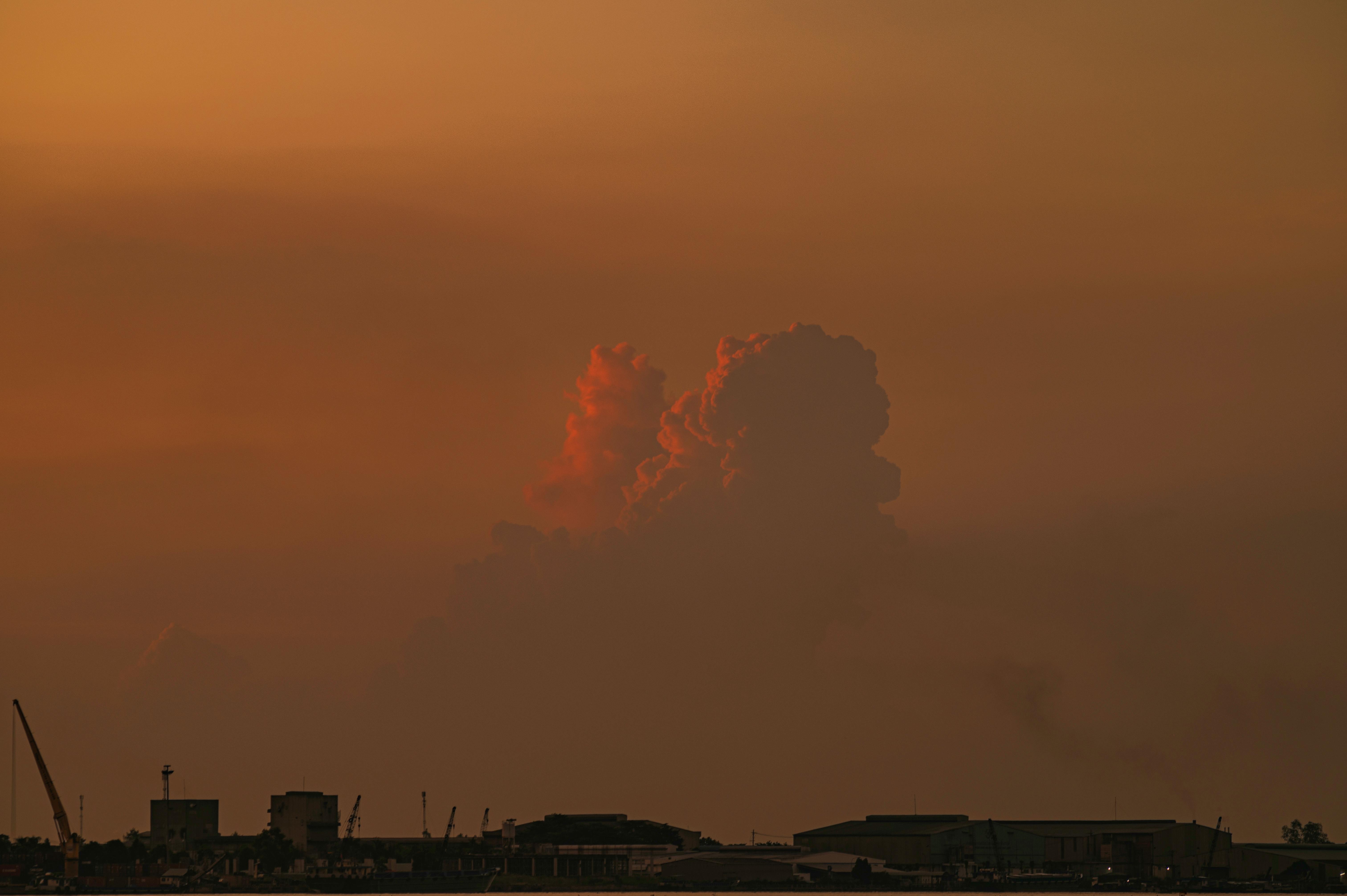 Silhouette of industrial buildings against a vibrant sunset in Cao Lãnh, Vietnam.