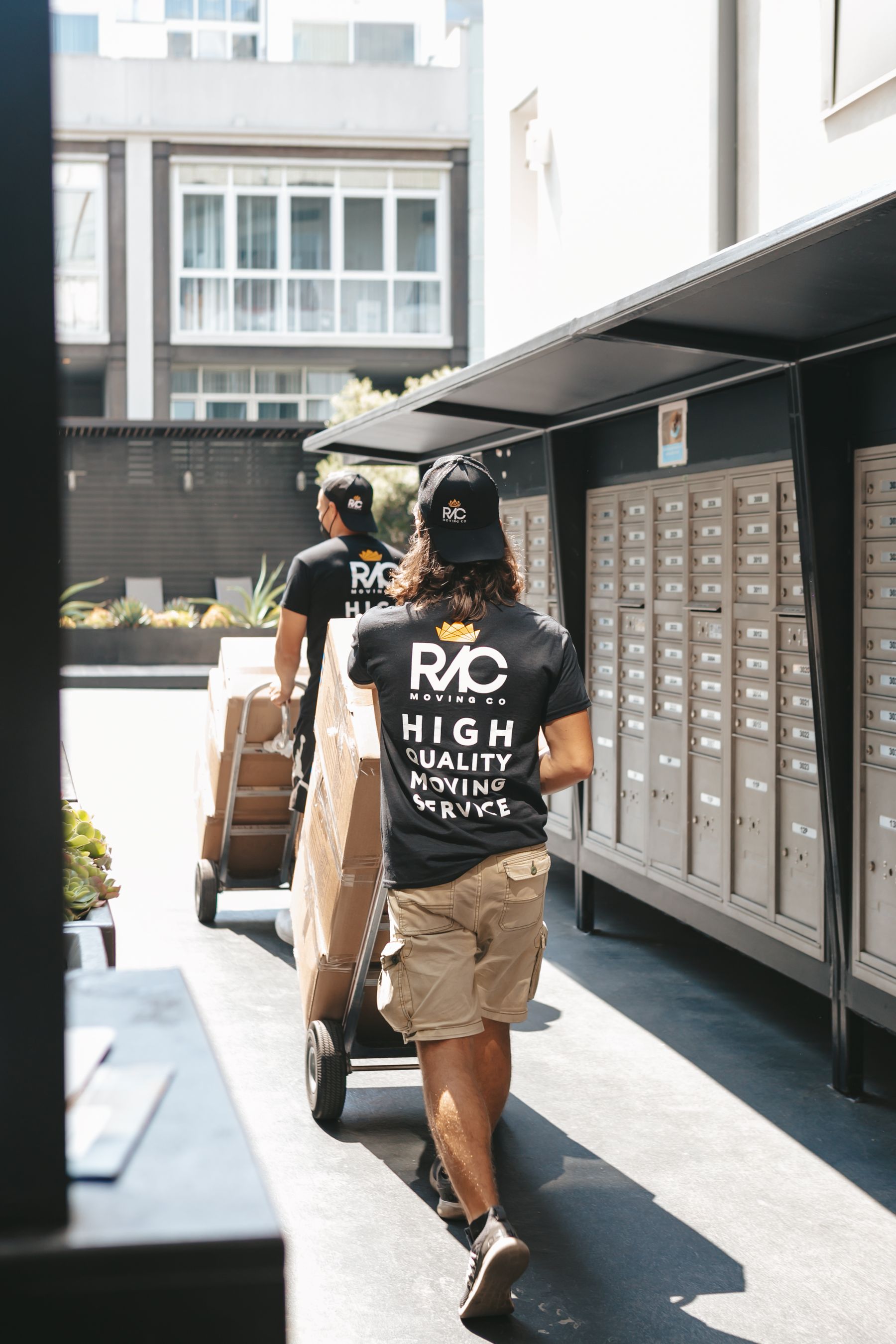 Movers pushing carts with boxes during a commercial relocation