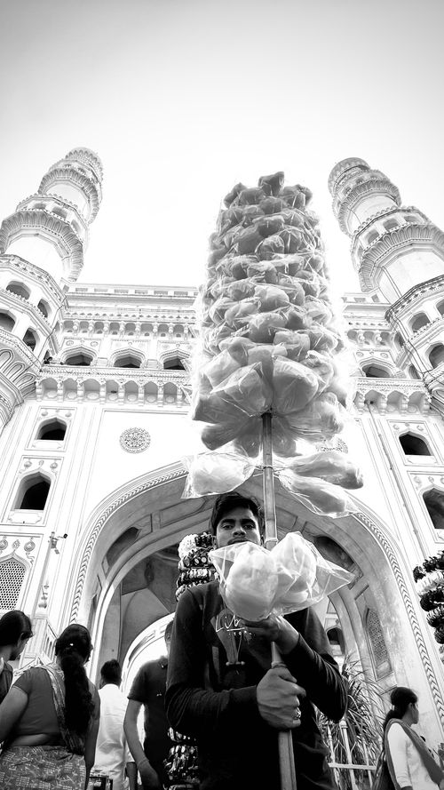 Free Black and white photo of a man selling cotton candy at the Charminar, Hyderabad, showcasing the iconic landmark. Stock Photo
