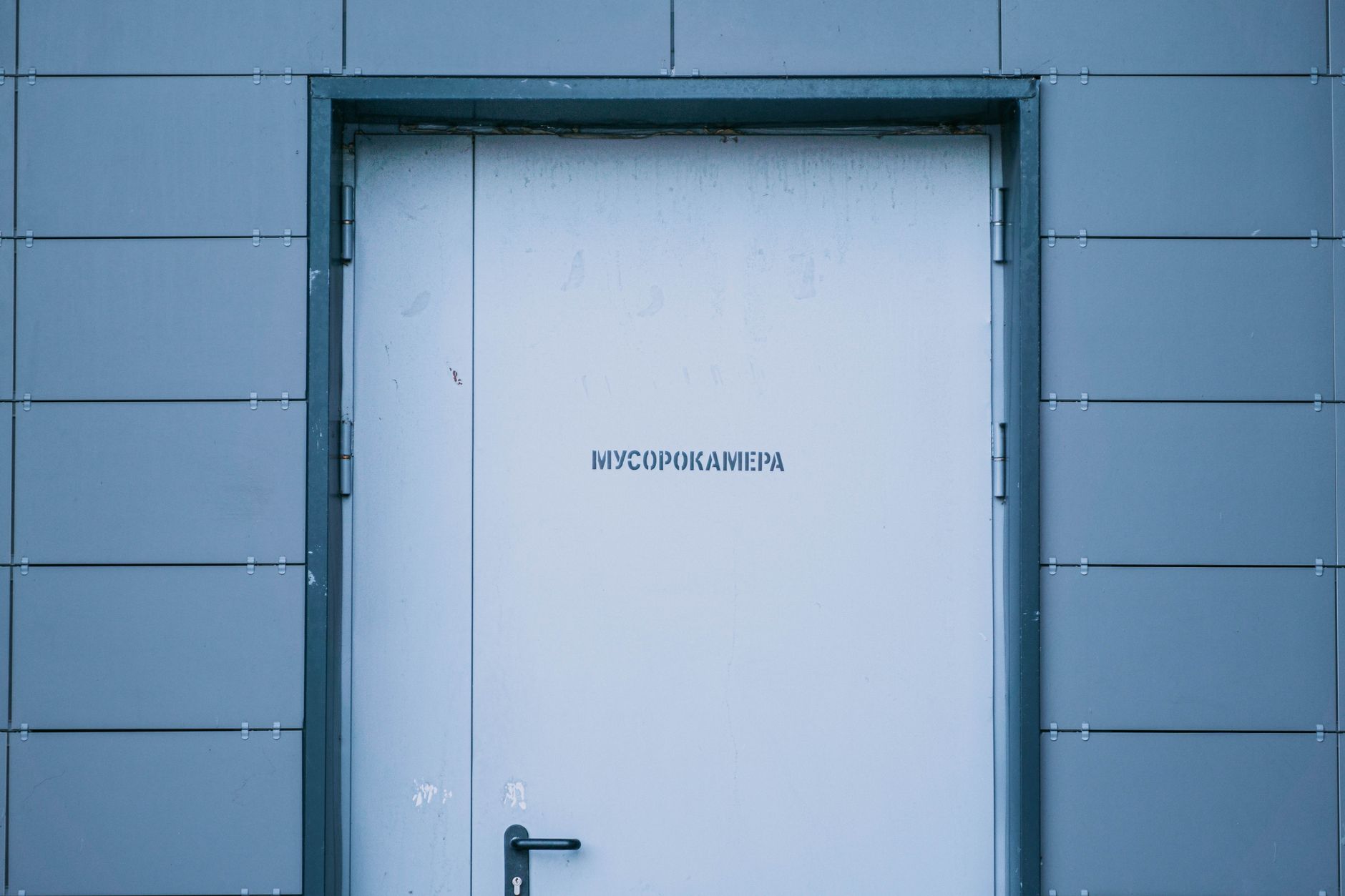 Sleek industrial doorway in Moscow, featuring a minimalist design against a grey wall.