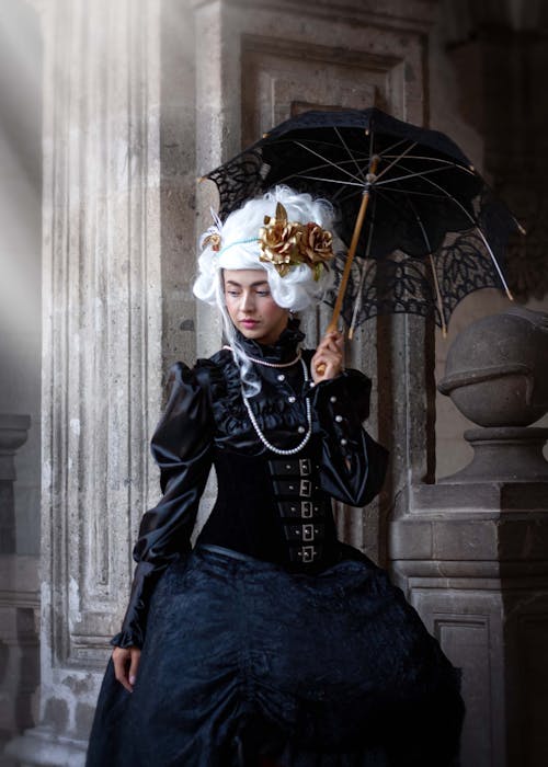 A woman in a gothic costume holding an umbrella