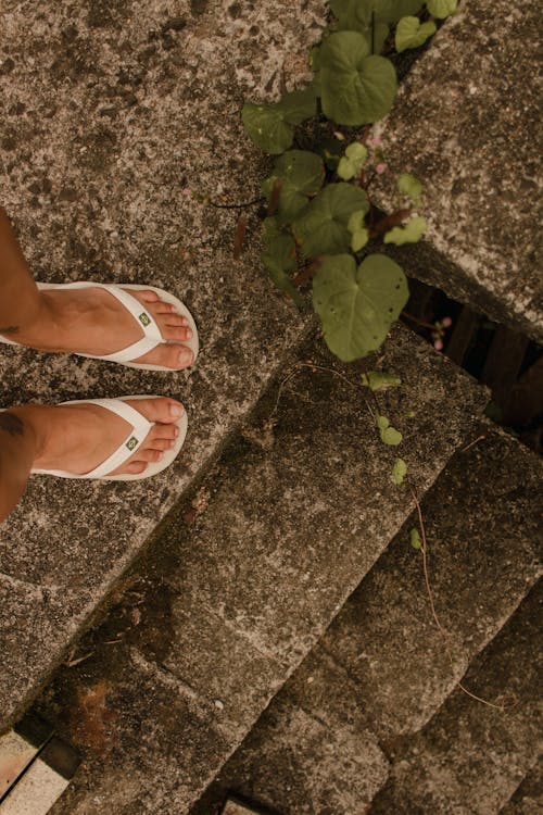 A person wearing flip flops on some steps
