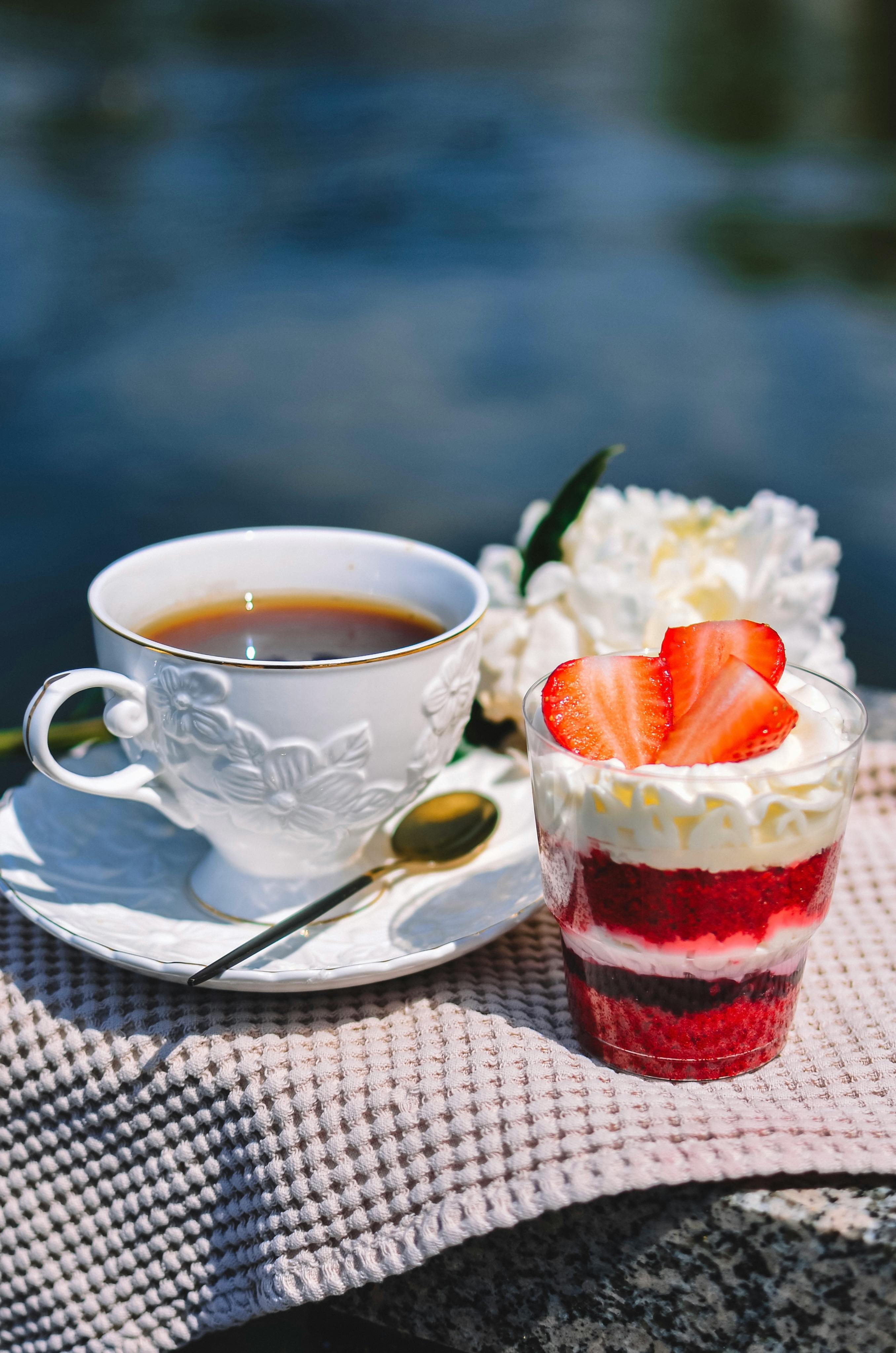 Elegant presentation of coffee cup and strawberry dessert outdoors, perfect for lifestyle and food photography.