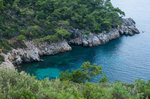 Free Explore this stunning coastal cove surrounded by lush greenery and clear blue waters in Antalya, Türkiye. Stock Photo