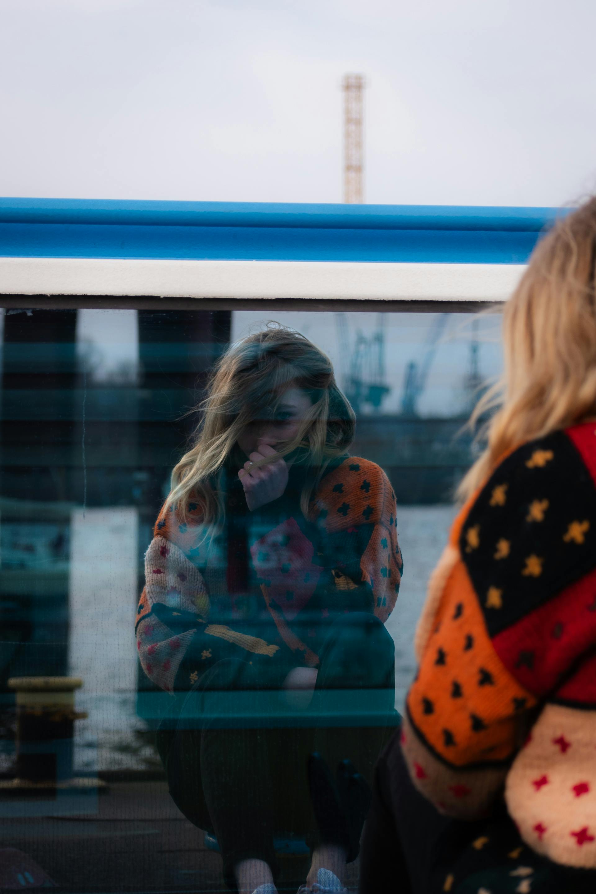A reflective moment mirrored on glass near an urban harbor.
