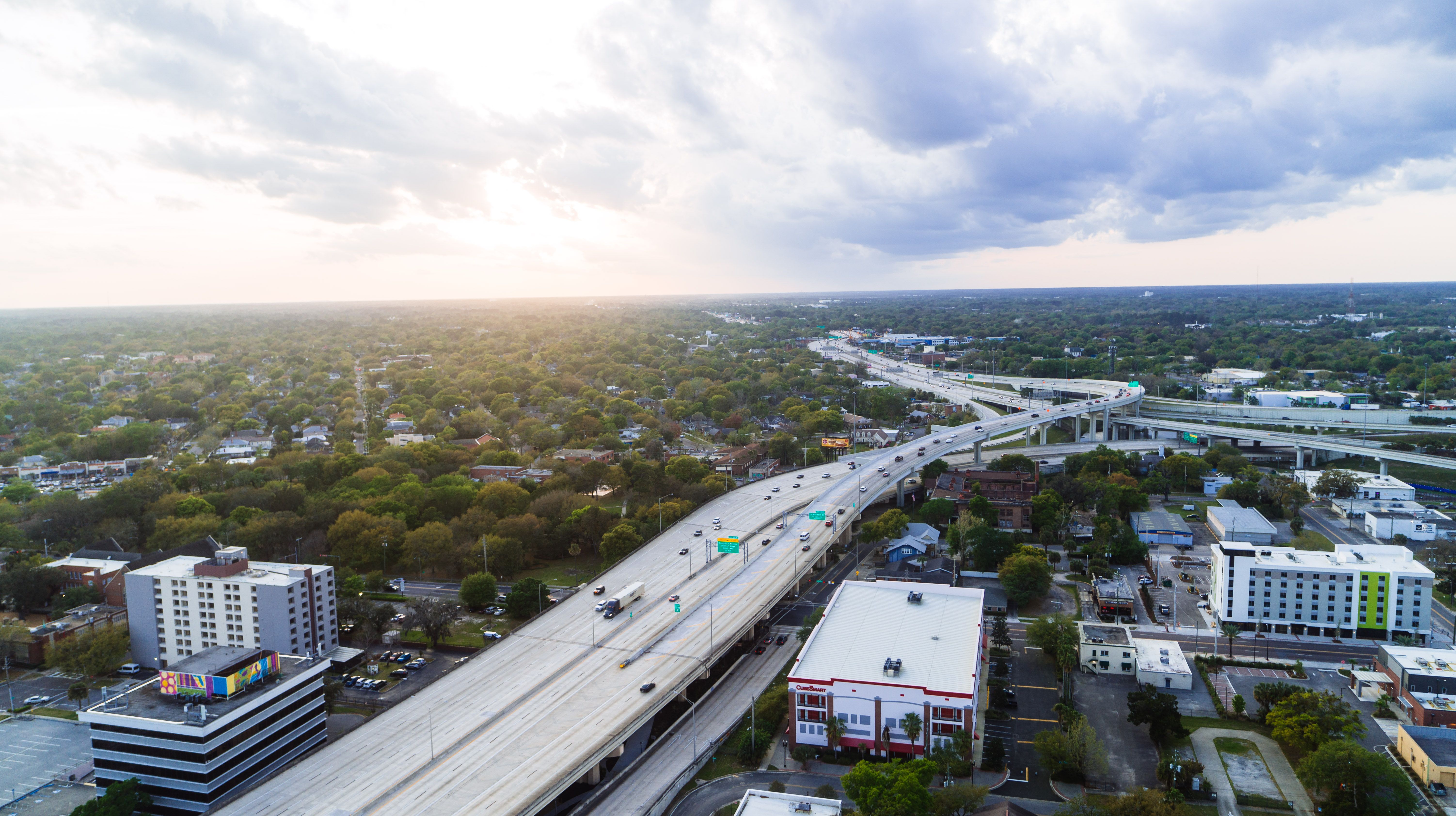 Breathtaking Take a Thrilling 85 Miles Private Helicopter Tour to Space Coast Review 2026 - Stunning aerial shot of Jacksonville's highway network with modern buildings at sunset.