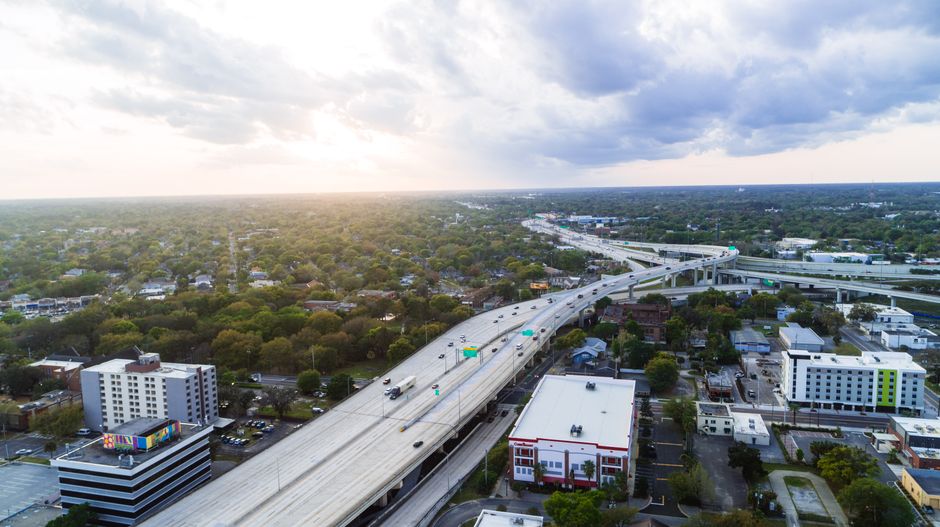 Breathtaking Take a Thrilling 85 Miles Private Helicopter Tour to Space Coast Review 2026 - Stunning aerial shot of Jacksonville's highway network with modern buildings at sunset.