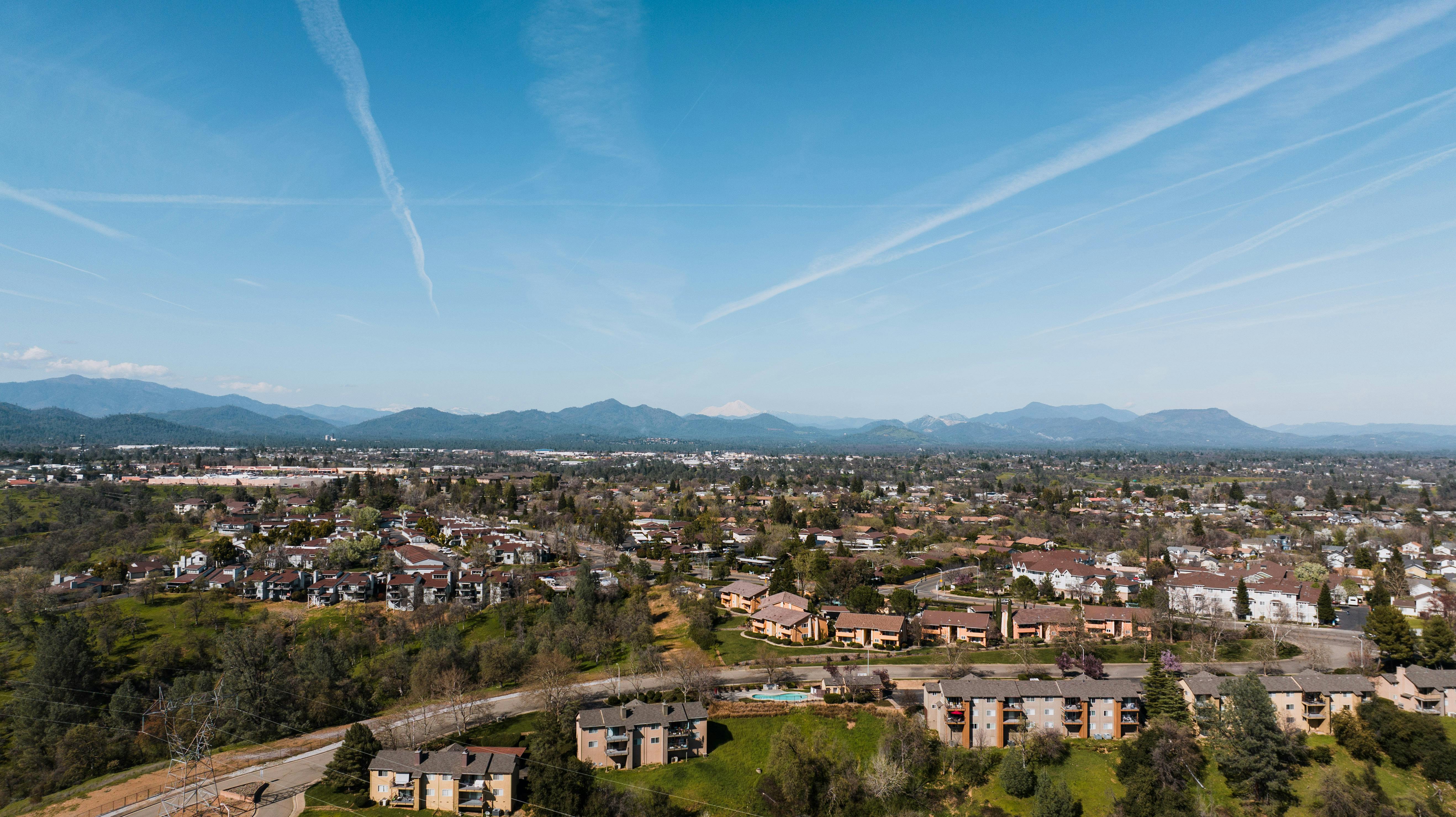 Expansive aerial view of Redding, CA showcasing residential areas against a mountainous backdrop.