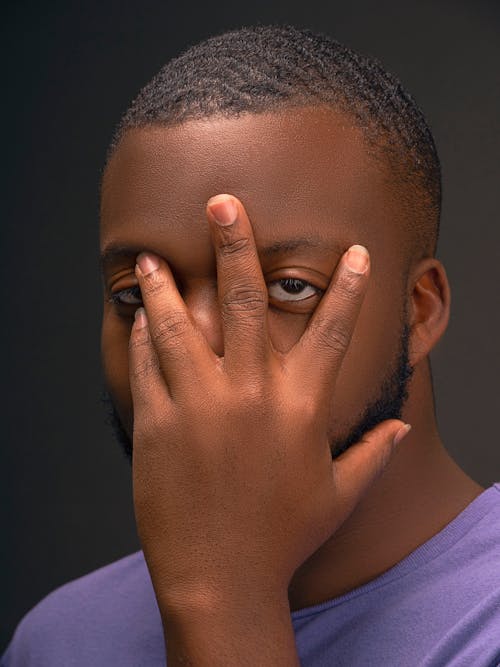 A man with his hands covering his eyes