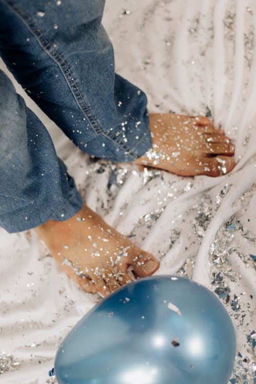 A person's feet and legs are covered in glitter