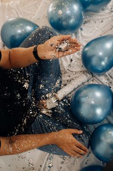 Festive New Year's Eve scene featuring blue balloons, glitter, and a confetti popper. Perfect for party themes.