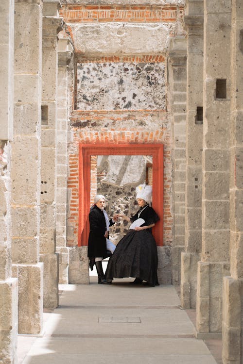 A couple in period dress walking through an archway