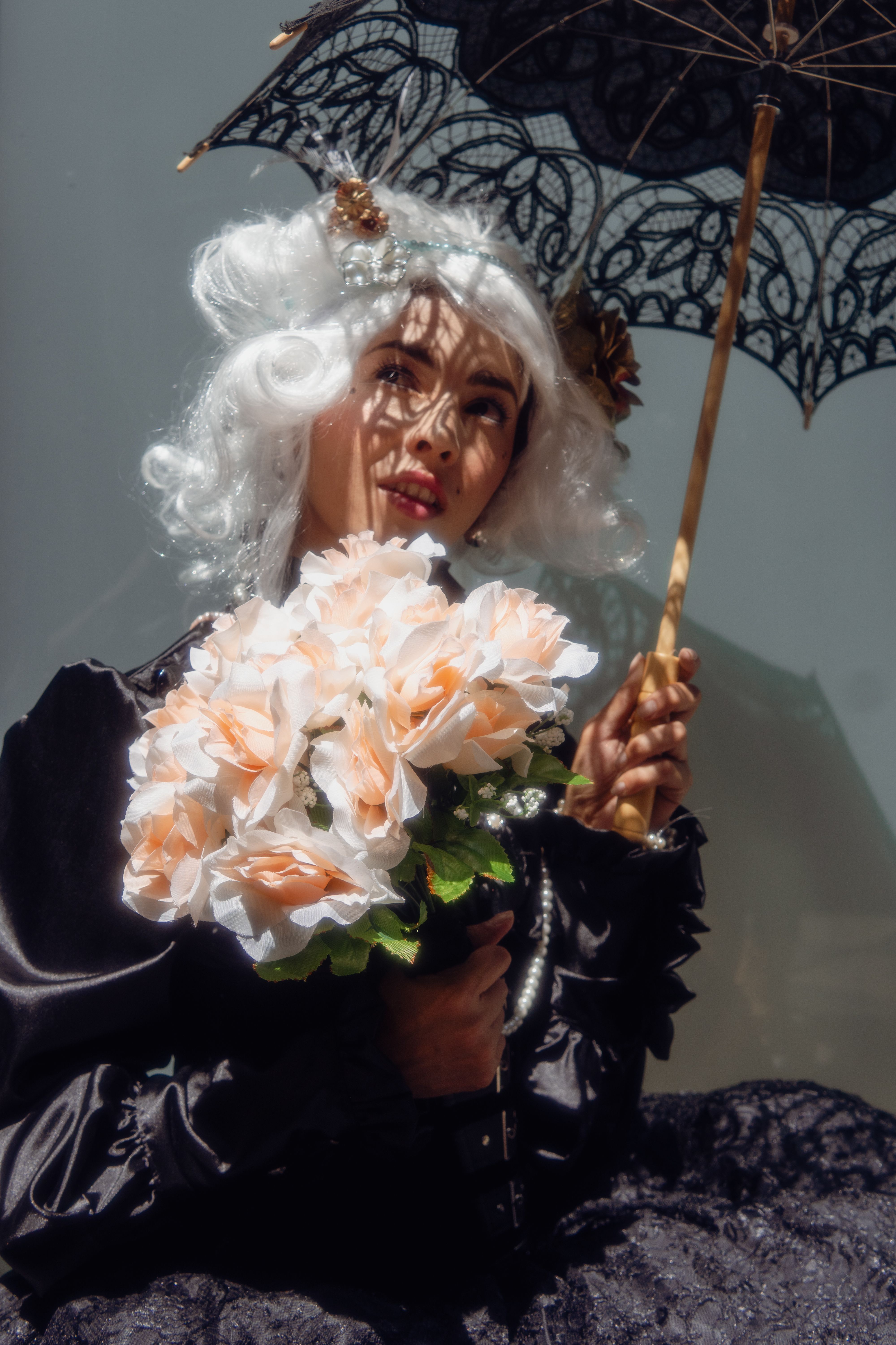 Elegant historical portrait with a woman holding a bouquet and parasol.