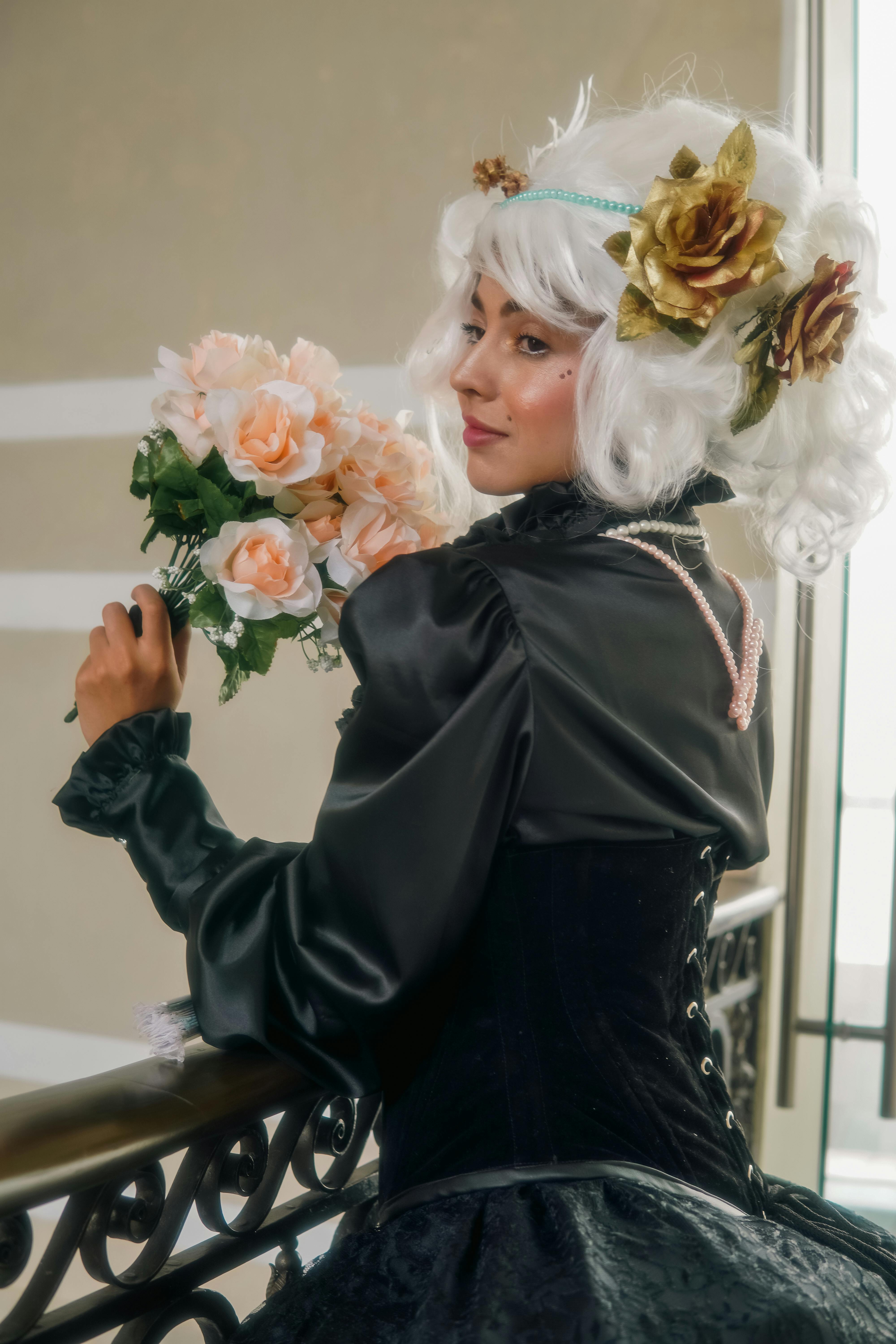 Elegant woman with white wig holding a bouquet in vintage costume, capturing timeless beauty.