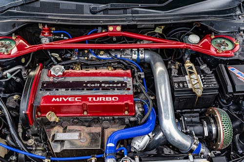 A car engine with a red and blue hose