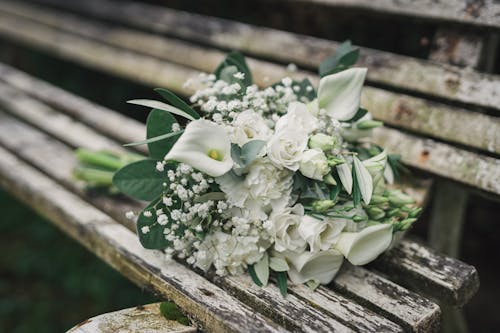 A bouquet of white flowers on a wooden bench