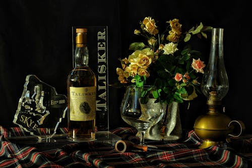 Roses Jaunes Et Roses Dans Un Vase à Côté De La Photographie En Gros Plan De Bouteille De Vin