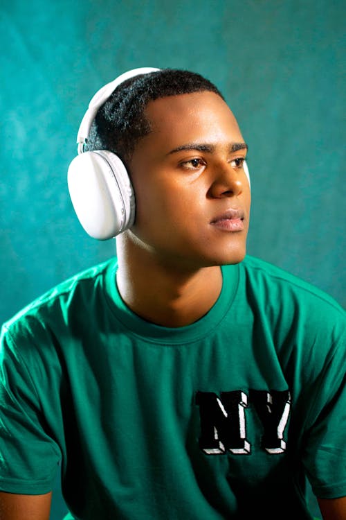 A young man wearing headphones and a green shirt