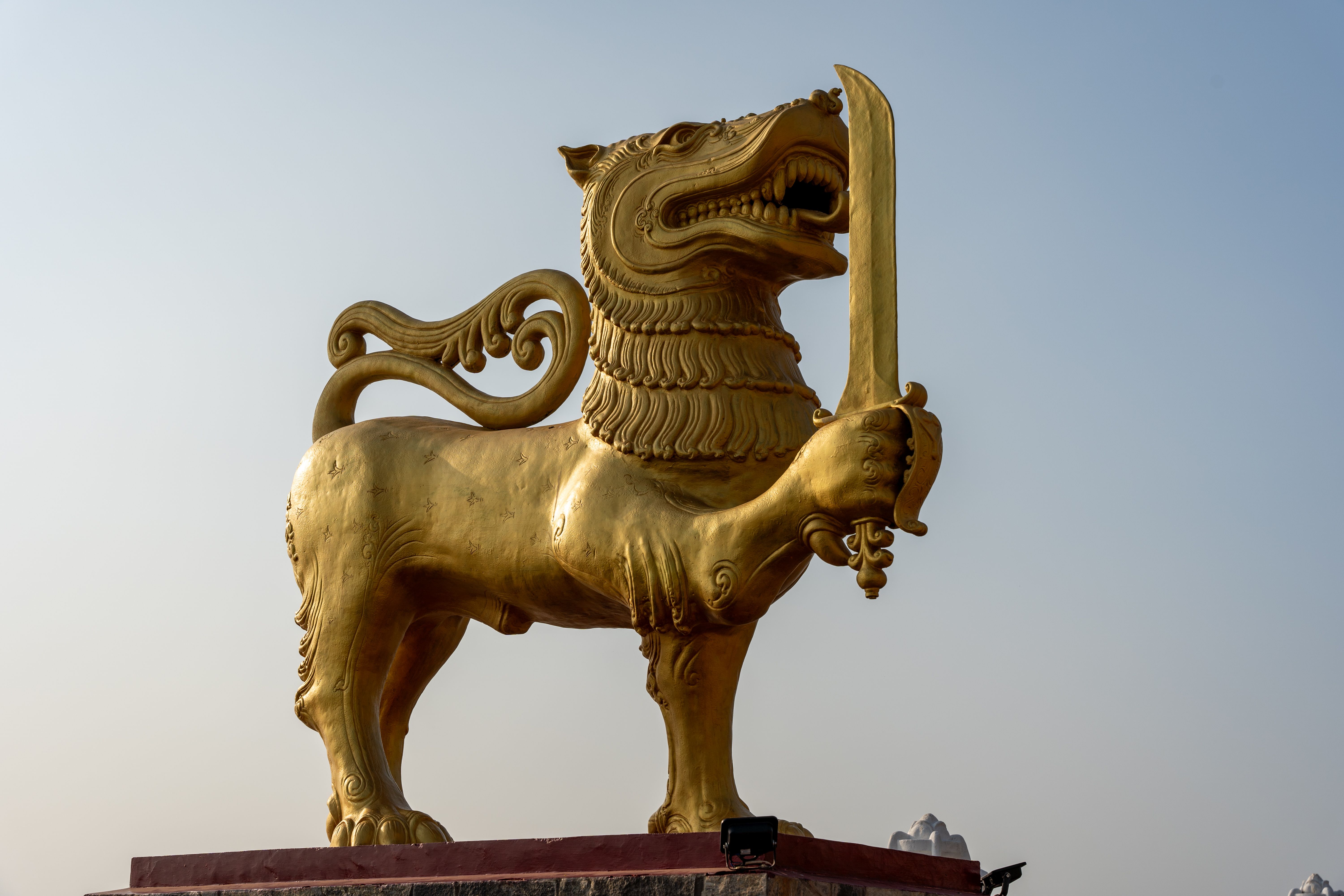 Golden lion statue symbolizing traditional art in Sri Lanka under clear skies.