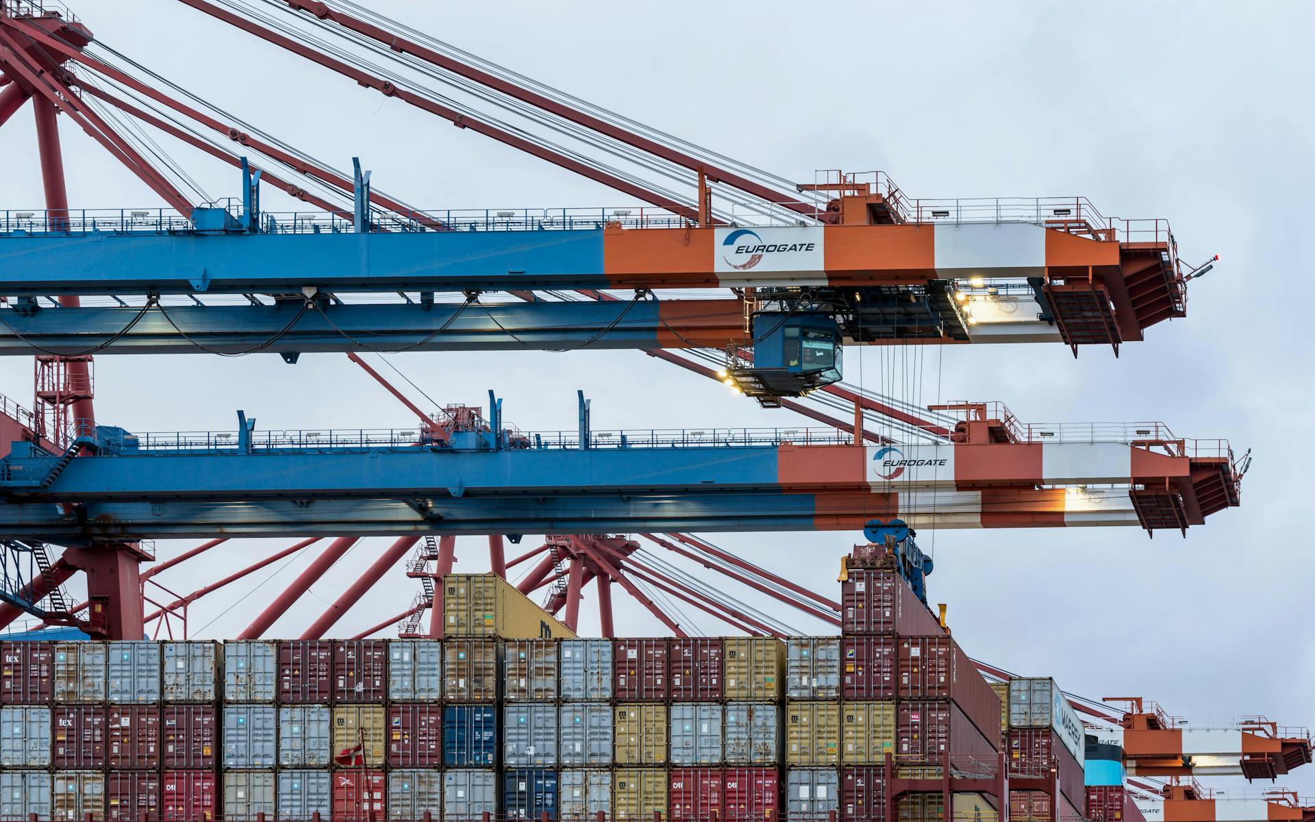Cranes loading cargo containers at Hamburg's shipping port.