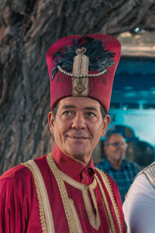 Free Portrait of a man in traditional Tunisian attire with elaborate red hat and feathers in La Marsa. Stock Photo