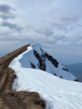 Snow-covered mountain ridge under a bright, clear sky in winter season.
