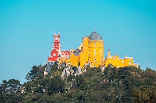 A yellow castle sits on top of a hill