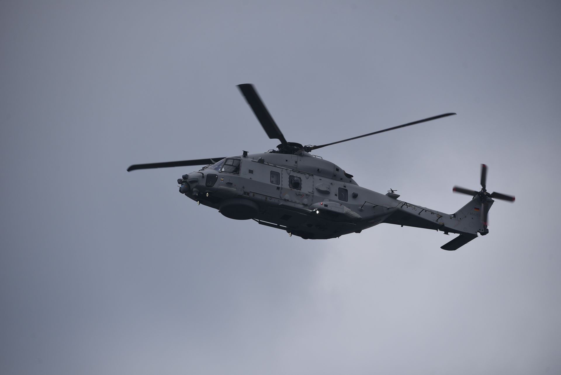 Un hélicoptère militaire en vol sous un ciel couvert