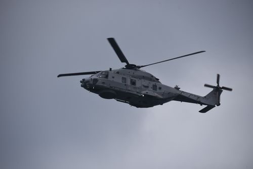 Free A military helicopter captured mid-flight against a cloudy sky, showcasing aviation and defense technology. Stock Photo