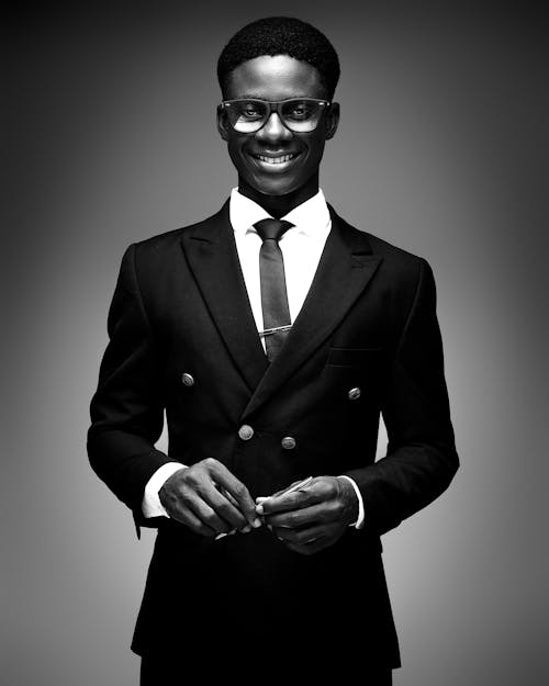 A black man in a suit and tie smiling