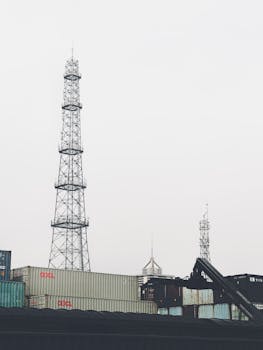 Container yard in Bin Hai Xin Qu with transmission towers and overcast sky.