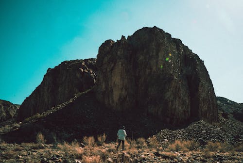 Person Standing in Front of Hill