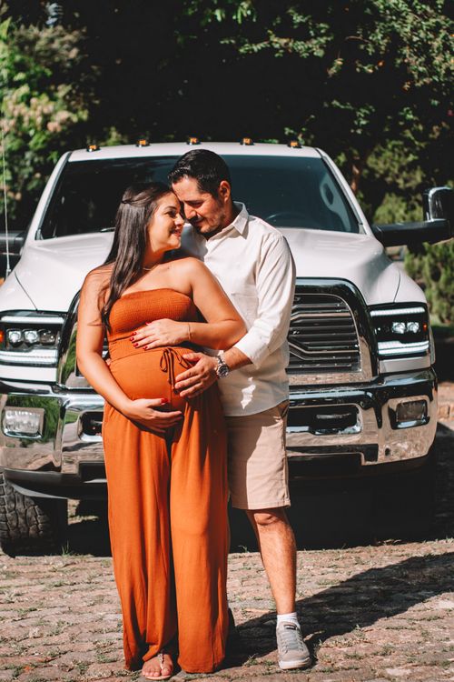 Man Standing and Hugging Pregnant Woman in Orange Dress · Free Stock Photo