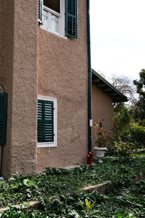 A house with green shutters and a green lawn