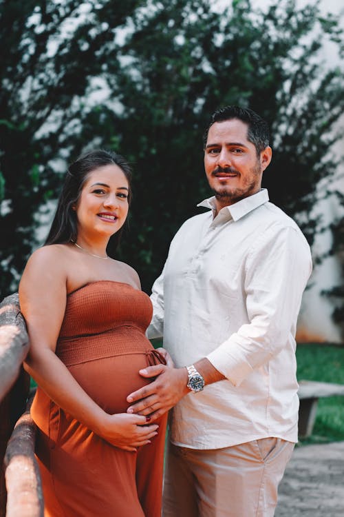 A pregnant woman and her husband pose for a photo
