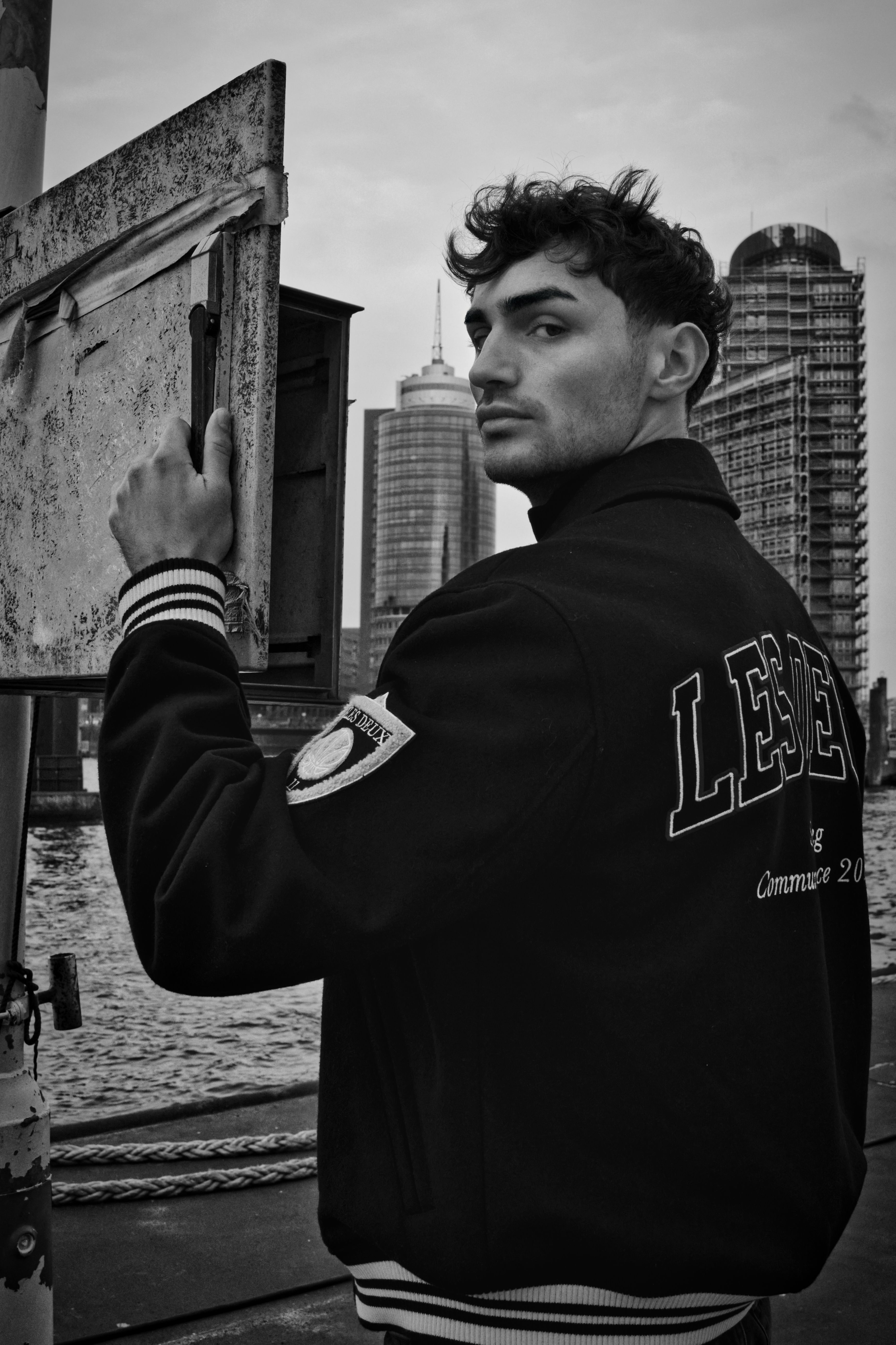 Striking black and white portrait featuring a male model in an urban Hamburg setting.