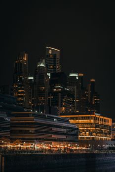 Night view of a vibrant cityscape with glowing skyscrapers and lights.