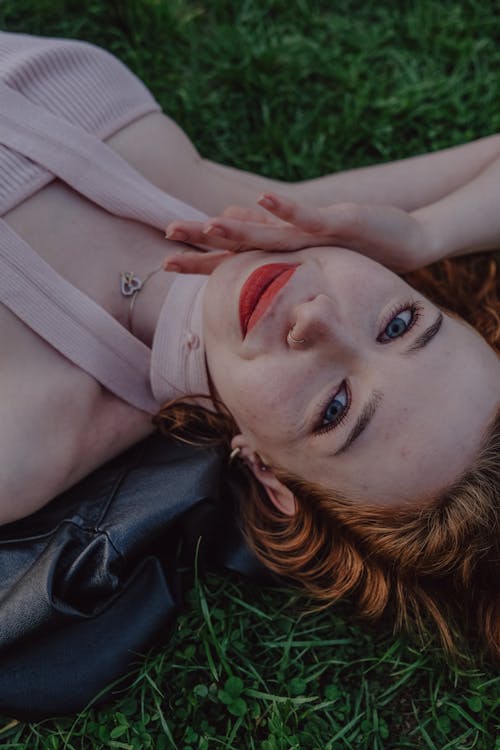 Free A woman laying on the grass with her head in the air Stock Photo