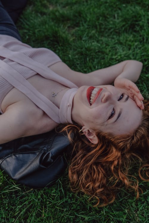 Free A woman laying on the grass smiling Stock Photo