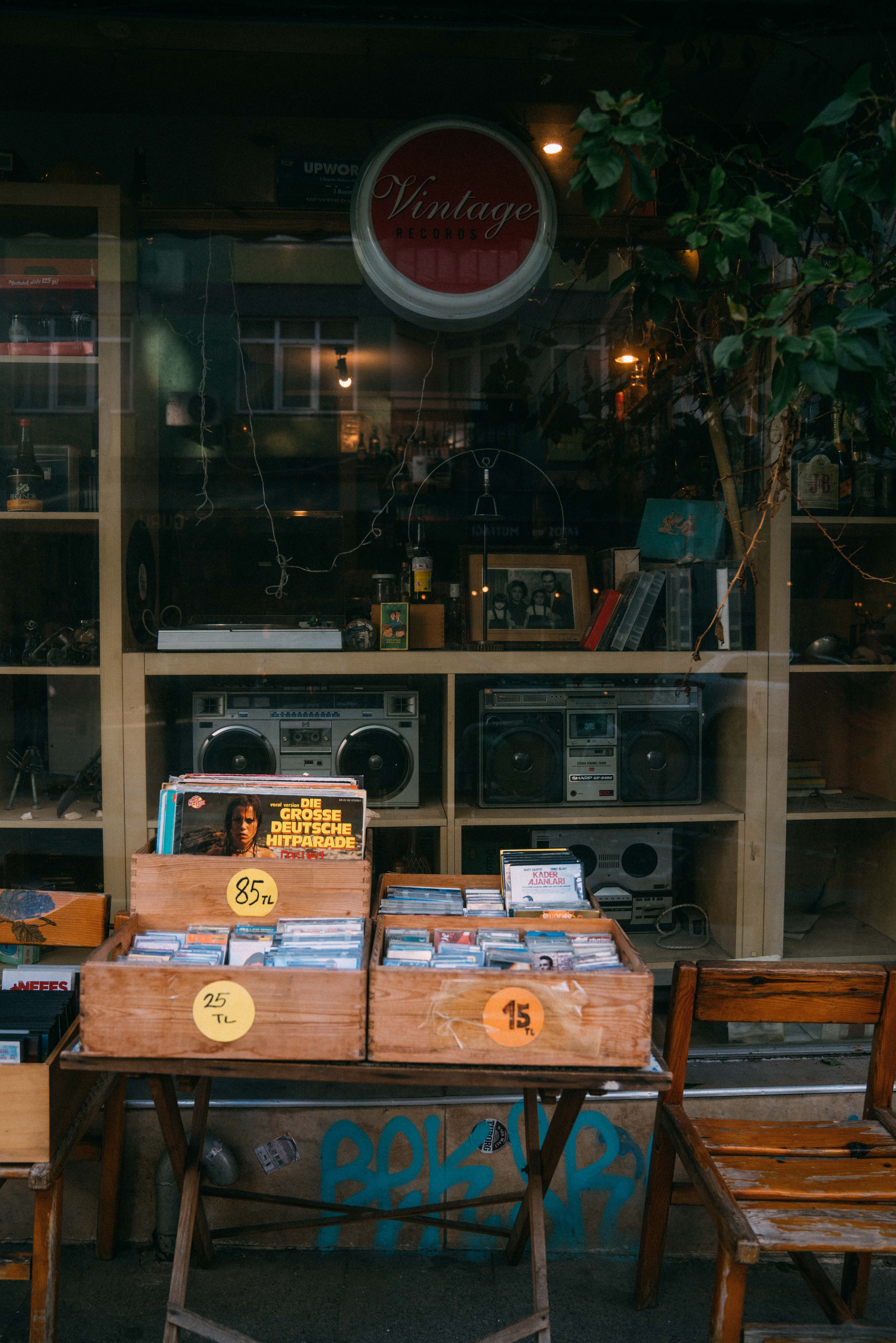 A display of vinyl records and vintage stereos outside a retro music shop.