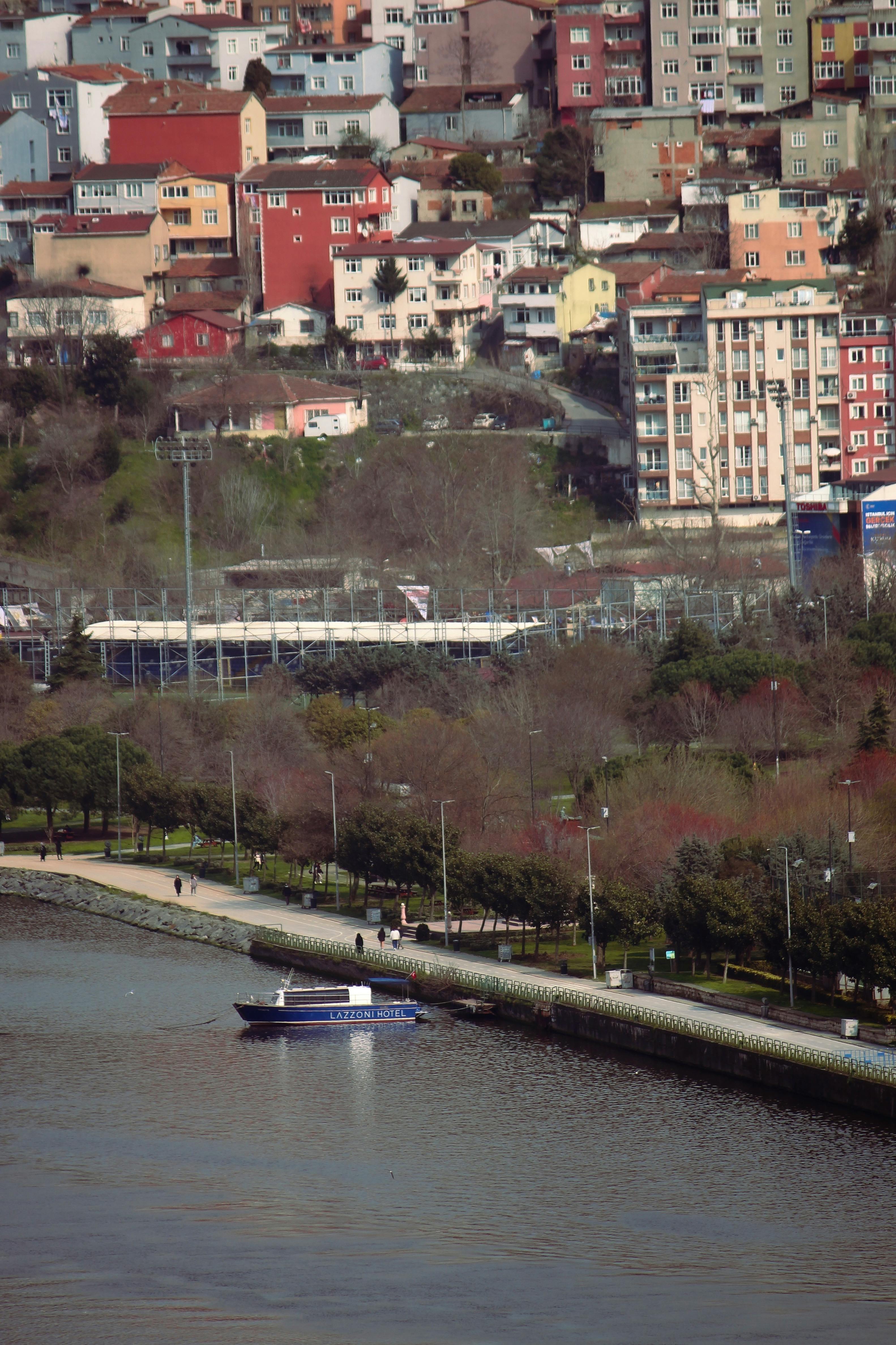 Aerial view of a motorboat on a river with a vibrant, colorful cityscape backdrop.