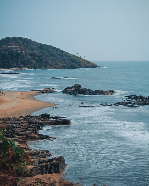 Free Beautiful aerial view of Vagator Beach with rocky shorelines and distant hills in Goa, India. Stock Photo